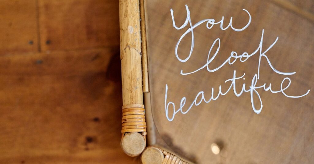 The words "you look beautiful" written on a mirror. 